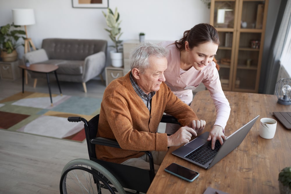 Woman Helping A Senior With Computer