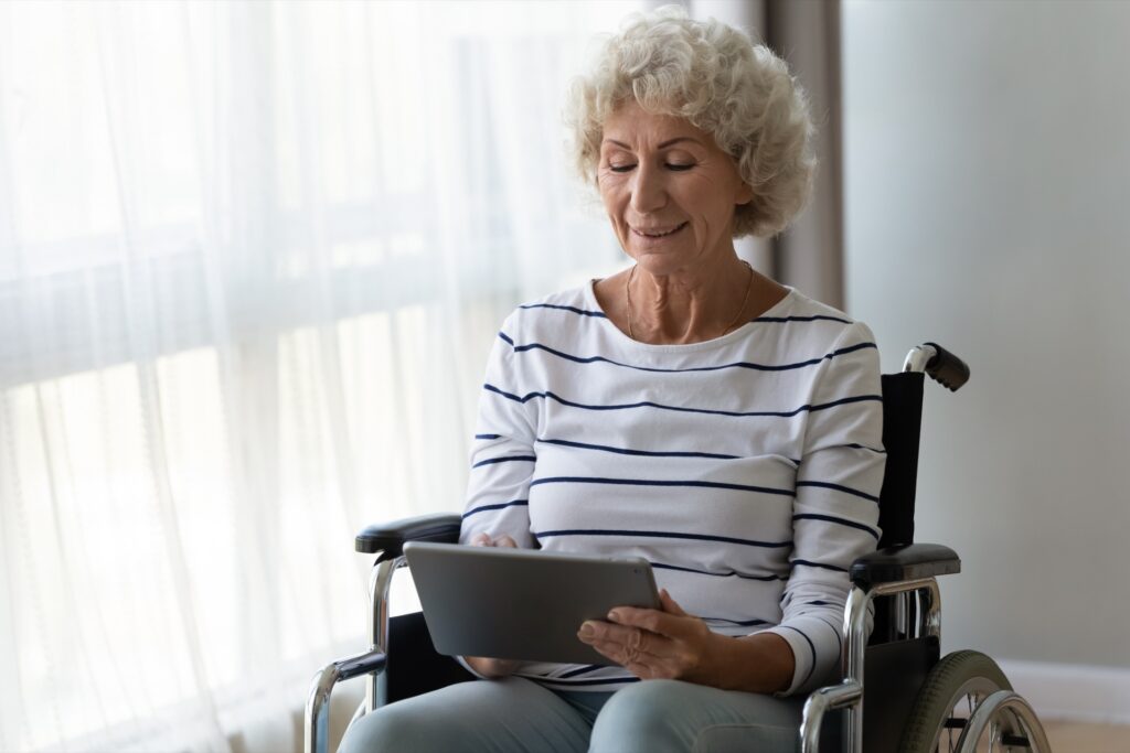 Woman In A Wheelchair Working On A Tablet