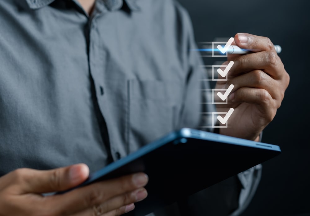 Person Holding A Tablet And Marking Digital TIcks